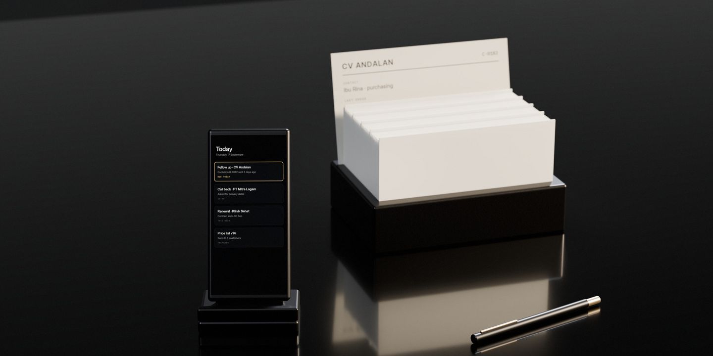 A card index on a dark stone desk with one customer’s card pulled up, and a phone standing beside it showing the follow-up that is due today