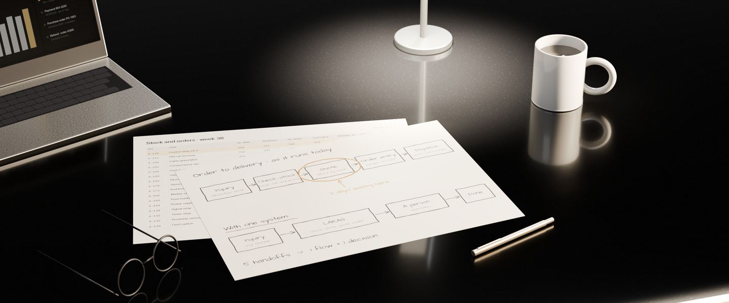 The end of a working day on a dark stone desk: a process map drawn by hand, one step ringed in pencil, a pair of glasses, a mug and a lamp still on