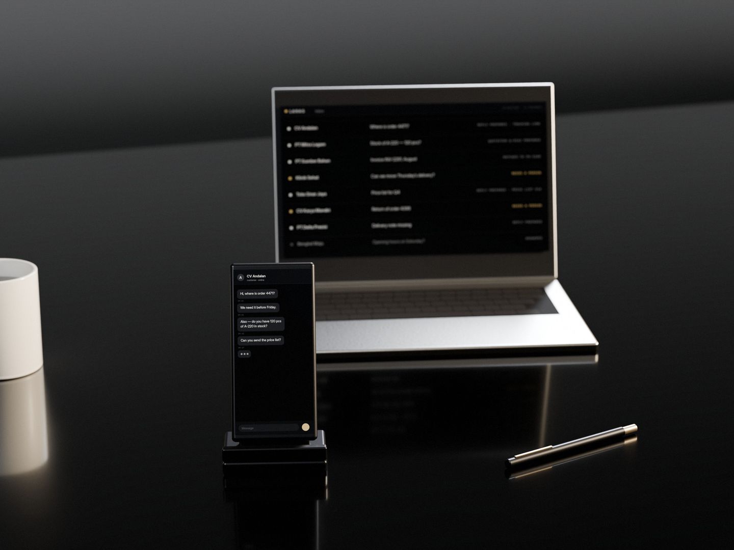 A phone standing on a dark stone desk, lit with a customer’s unanswered questions, a laptop behind it with the inbox filling up